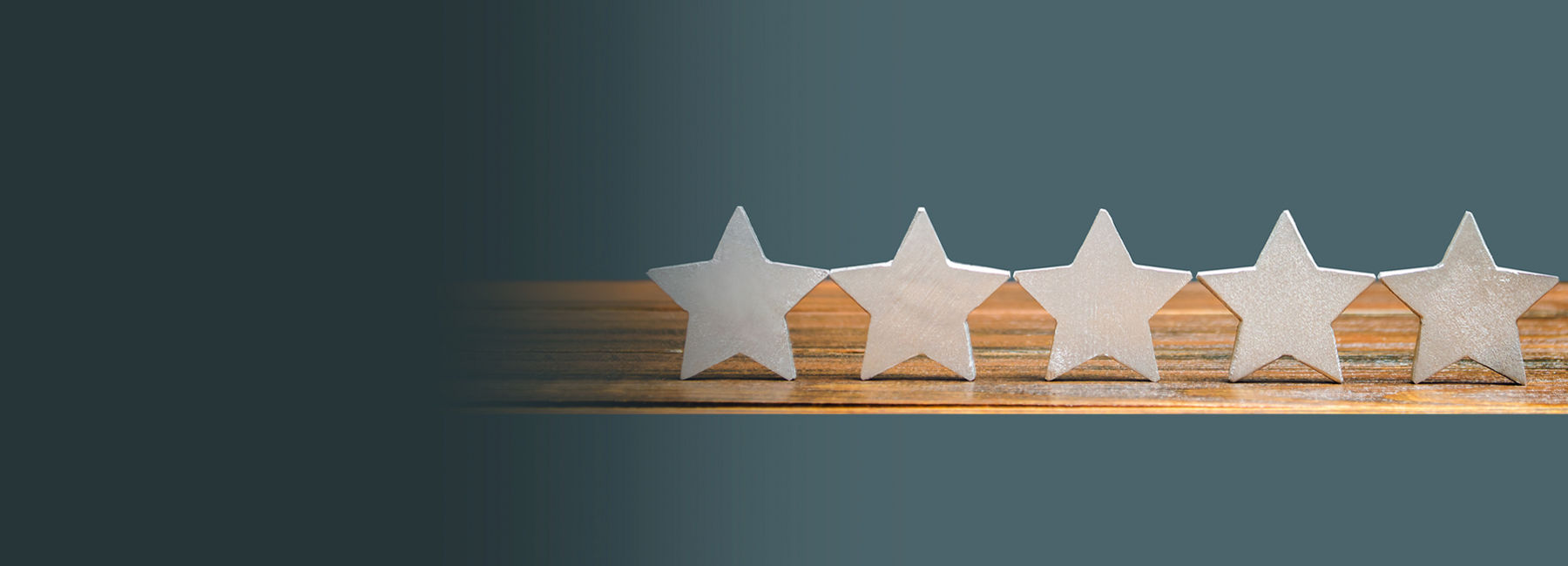 Five white stars aligned on wooden surface, Contact Center Experience | DXC Technology