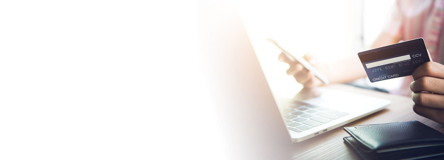 hand holding credit card at laptop, Card issuing | DXC Technology