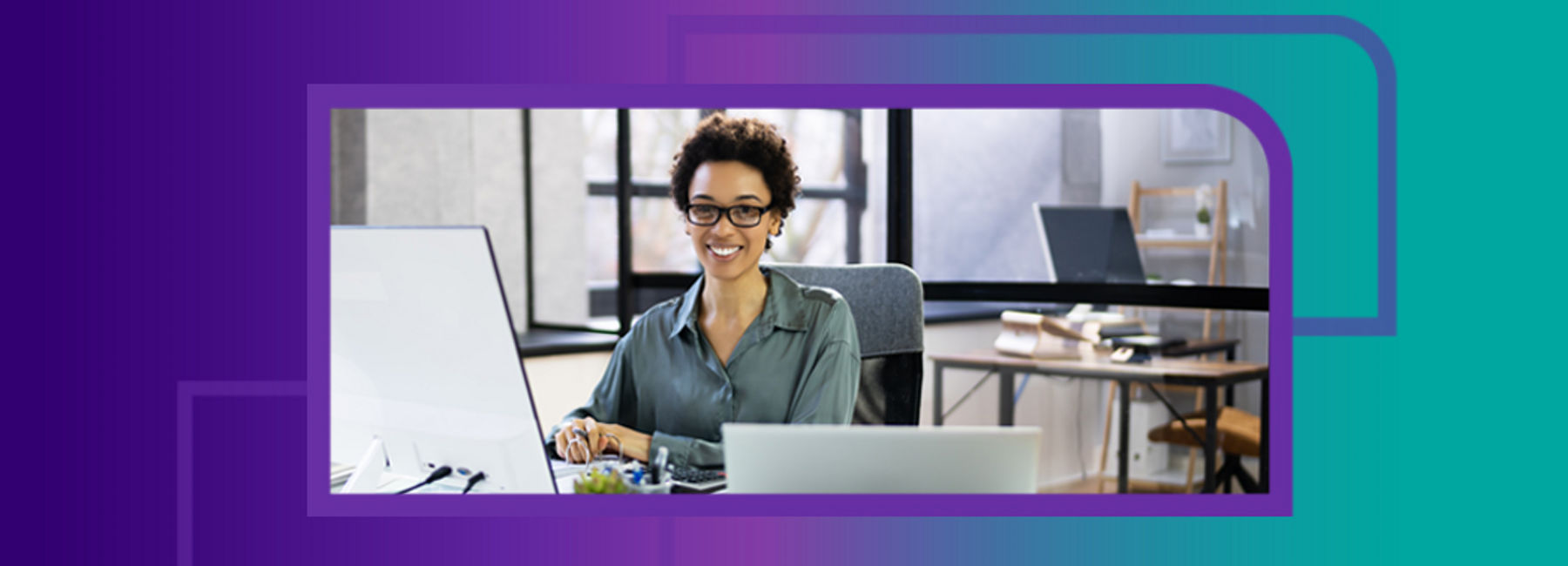 Woman sitting at desk, using big monitor with laptop on desk, VDA services | DXC Technology| DXC Technology
