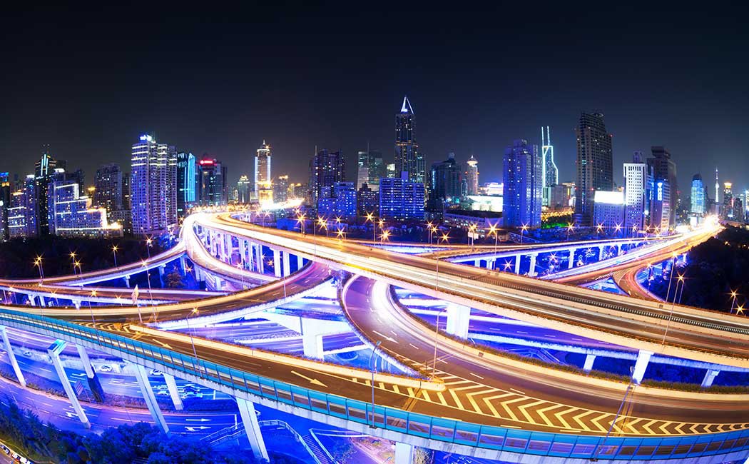 illuminated traffic on elevated expressway in modern city.