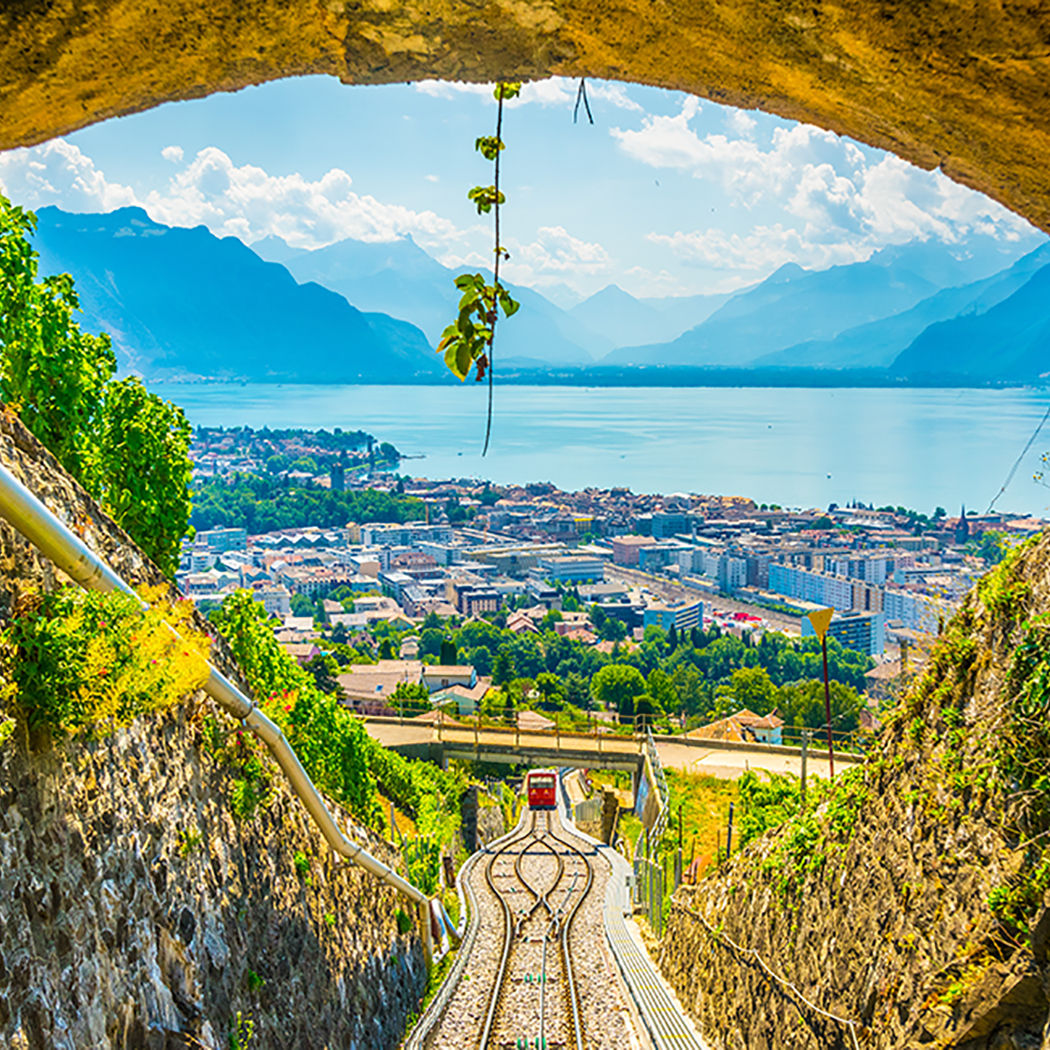 View through a rail tunnel in Switzerland towards mountains and blue lake, Swiss Rail (SBB) | DXC Technology Customer Stories