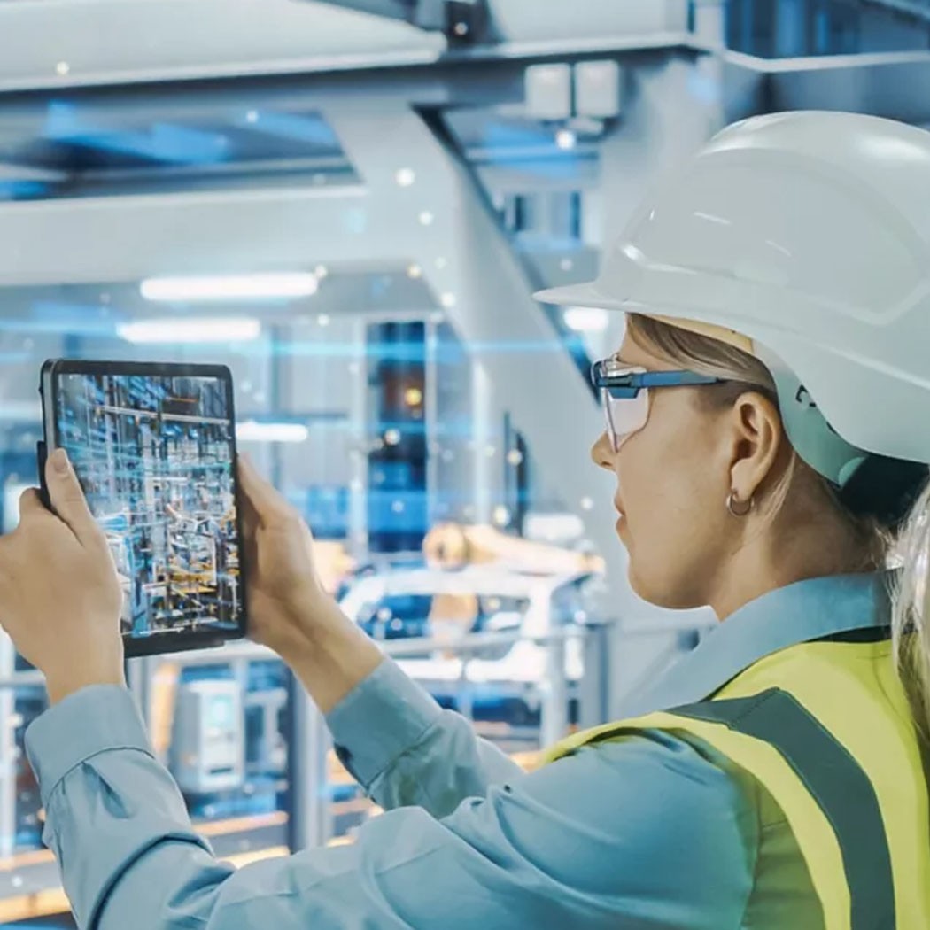 Woman uses tablet on manufacturing line - AI Readiness: Preparing Your Business for the Future | DXC Technology Insights