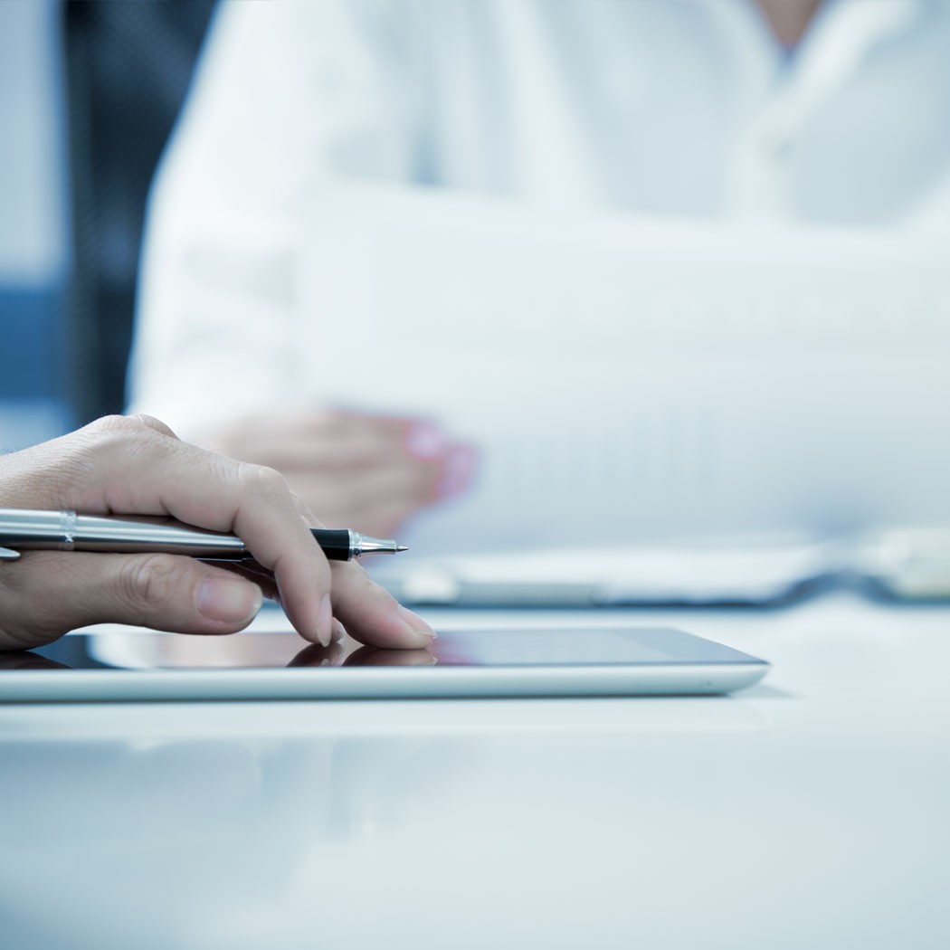 Two people revie data on paper and tablet - AI Readiness: Preparing Your Business for the Future | DXC Technology Insights