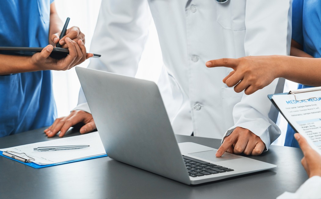 Medical staff discussing information on laptop - AI Solutions in Healthcare | DXC Technology Insights