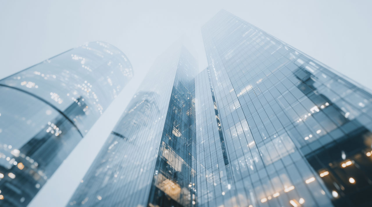 Skyscrapers with financial graphs and numbers overlay, Corporate Treasury, Financial Services | DXC Technology