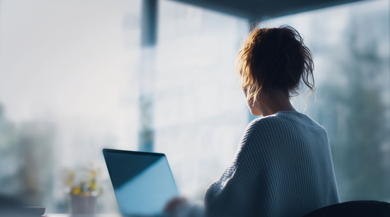 Person using pc and mobile representing managed services, Hogan Core Banking Platform | DXC Technology Platforms