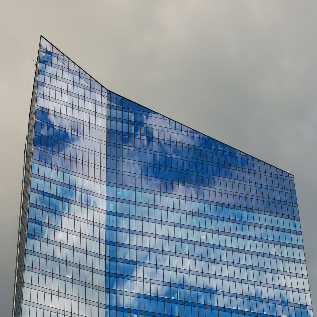 Building with windows reflecting clouds and grey sky, Managed Container Services | DXC Technology Insights