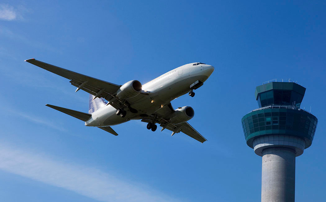 Plane flying past control tower, the future of AI in the aerospace industry | DXC Technology Insights
