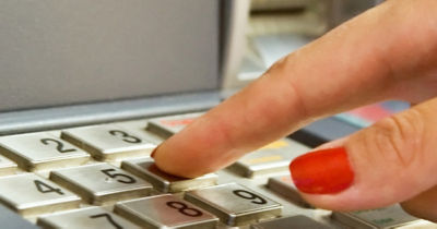 Woman entering pin at ATM