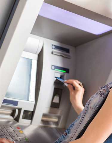 Junge Frau benutzt Geldautomat