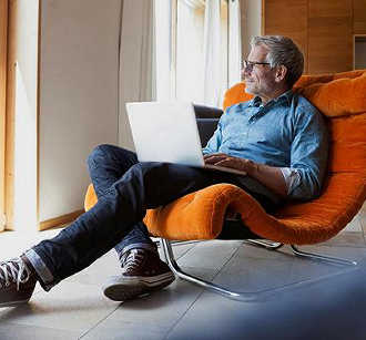 Man sitting in chair with laptop