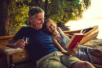 Older couple reading a book outside