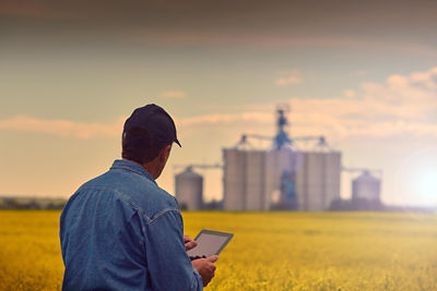 Farmer looking at a tablet while in his field