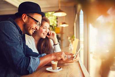 Couple looking at their smart phone at coffee shop