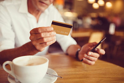 Man hand holding credit card in coffee shop