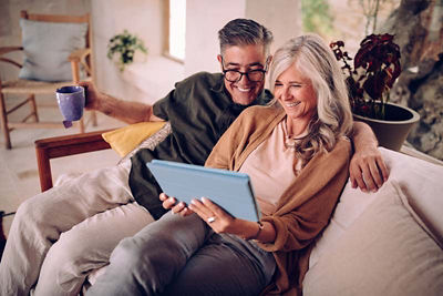 Mature couple on their couch looking at a tablet