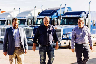 Transportation experts walking past semi trucks