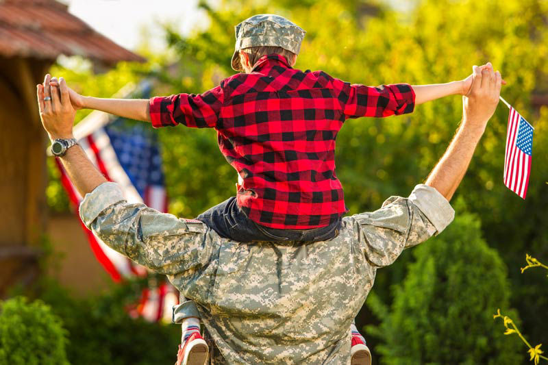dad in uniform piggy back ride - VA loan