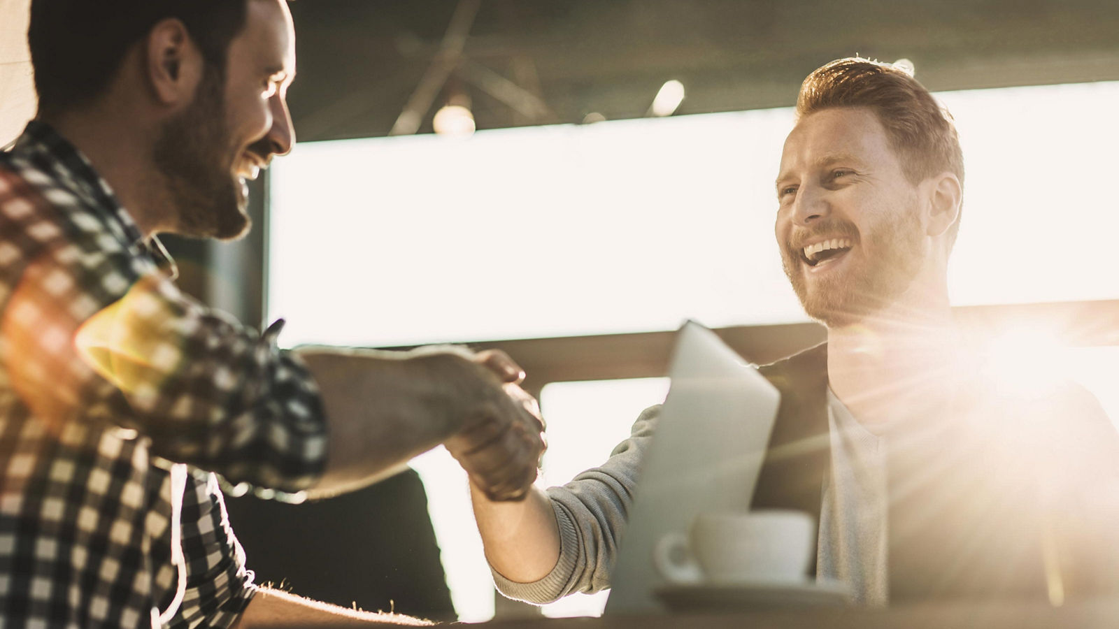 Two casually dressed businessmen shaking hands