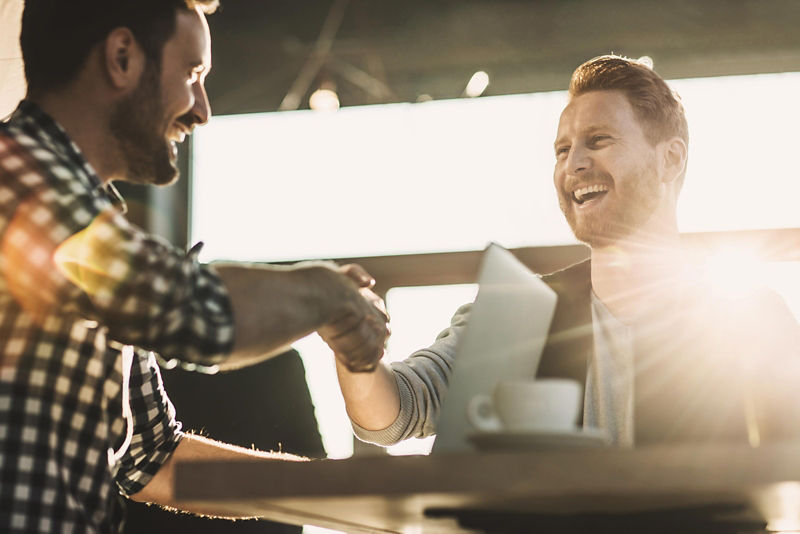 Two casually dressed businessmen shaking hands