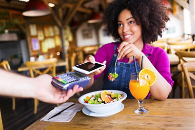 Woman paying for her meal with her phone