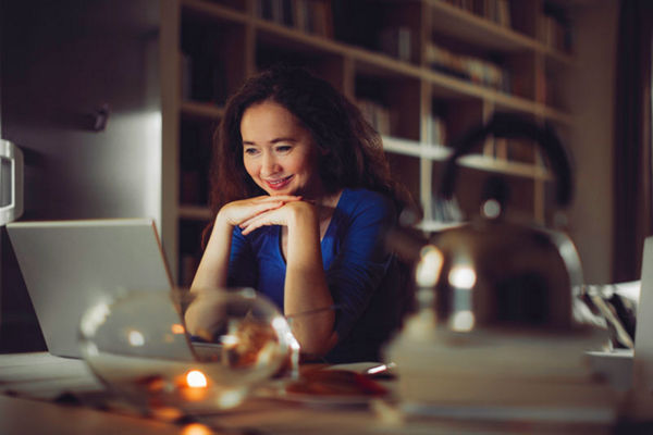 woman looking at computer hands folded