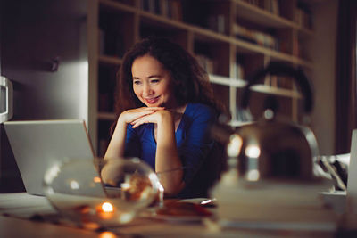 woman looking at computer hands folded