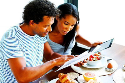 Couple looking at tablet over breakfast
