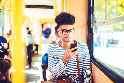 A young man checking his smart phone for job opportunities
