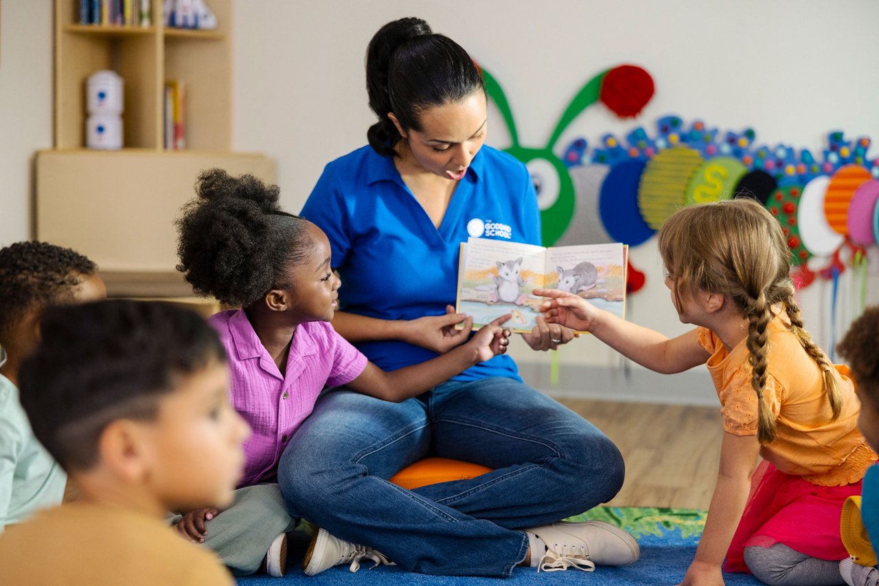 Teacher reading a book to children on a preschool classroom