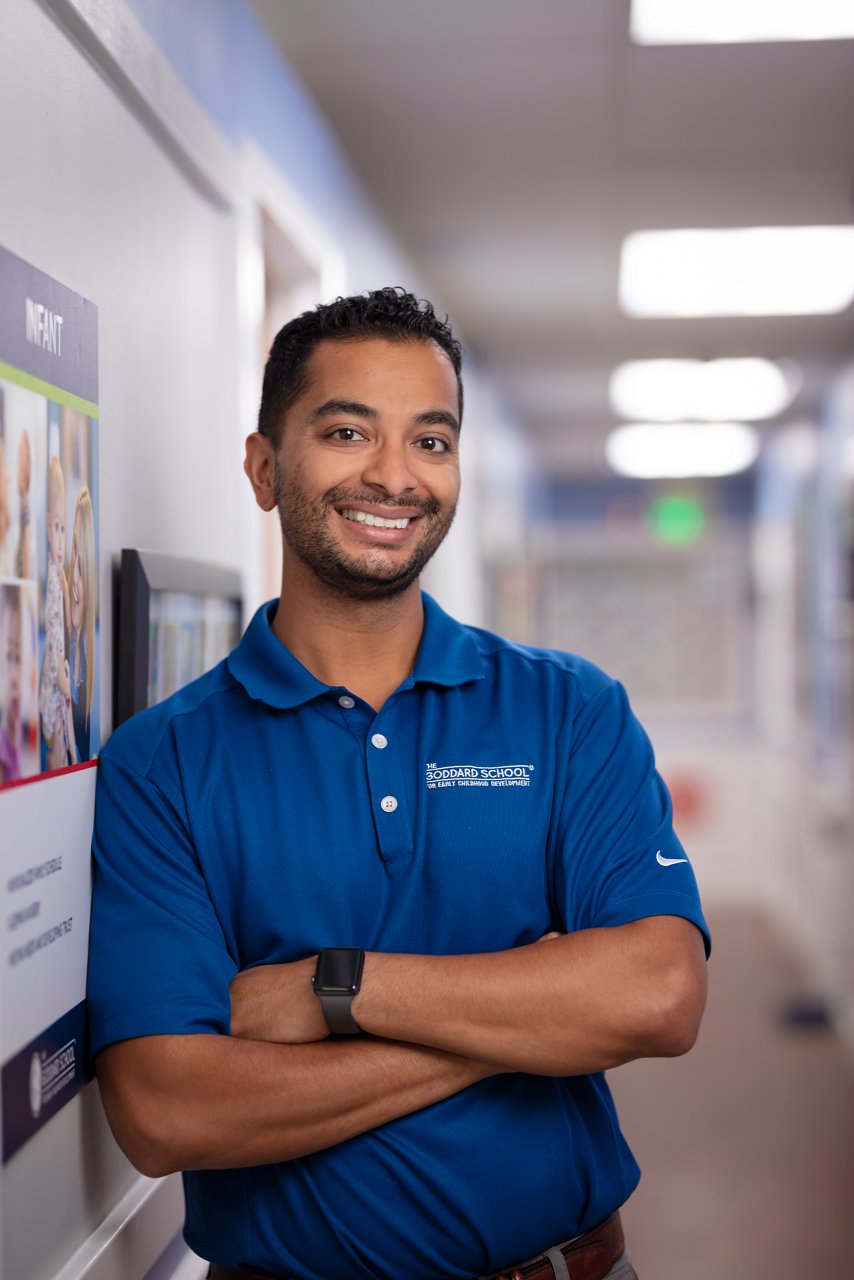 A Goddard School employee posing in a Goddard preschool hallway