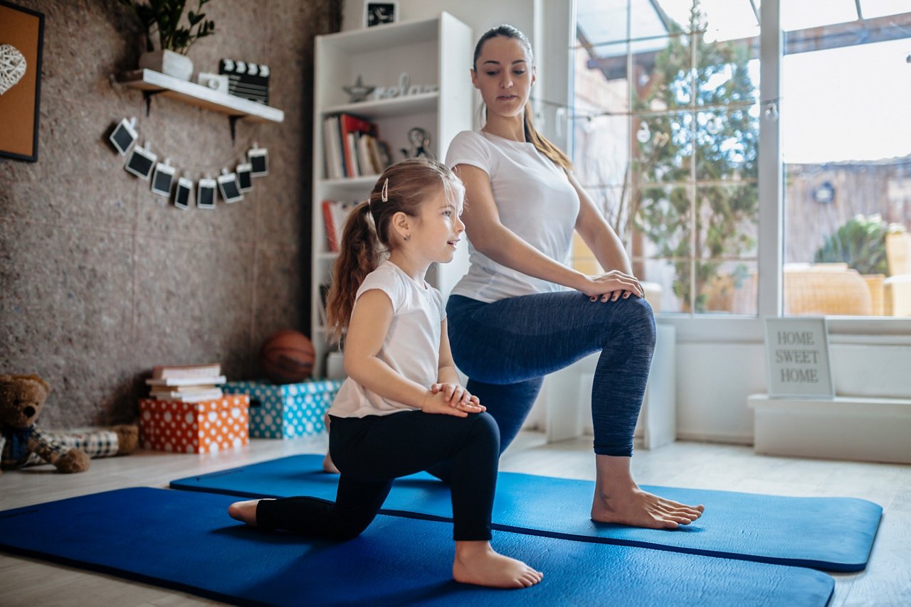 Mother and daughter working out together doing exercise at home