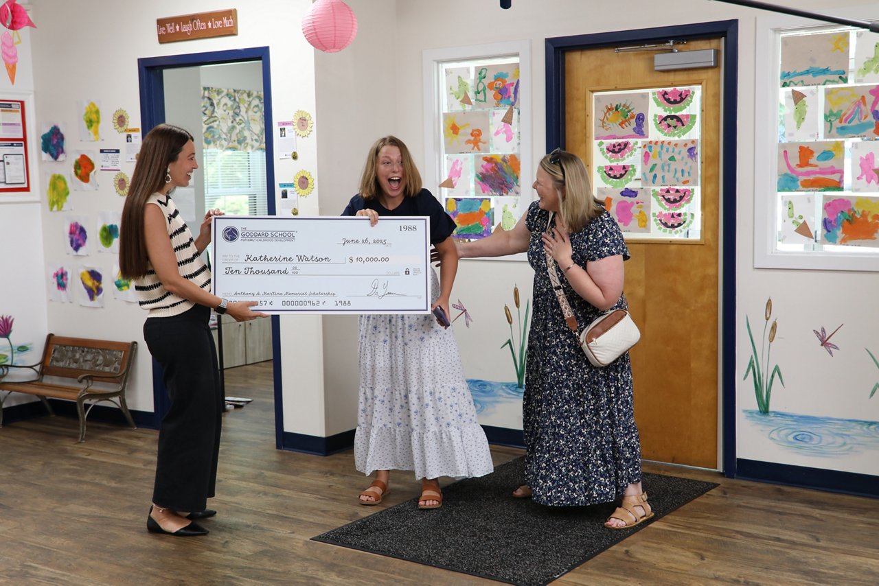 A surprised Katie Watson, Goddard School 2025 Anthony A. Martino Memorial Scholarship winner, receiving her giant check
