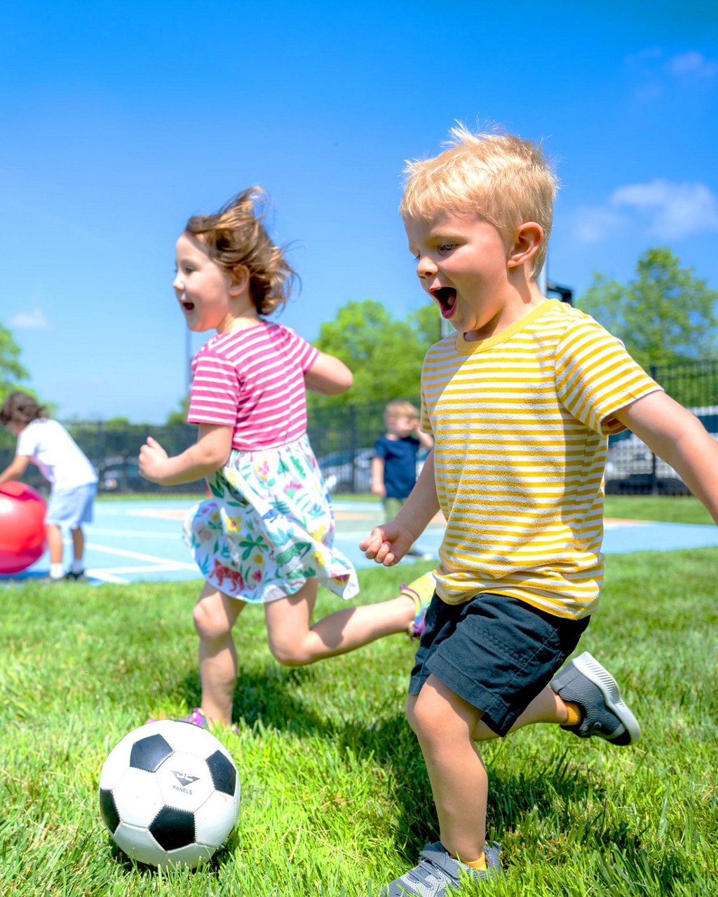 Children playing soccer in a field 