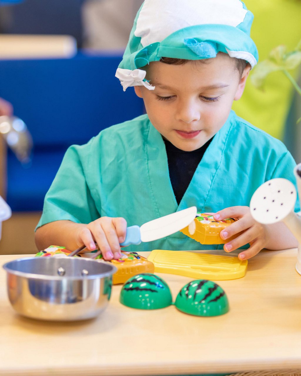 A child dressed in a costume playing with play food 