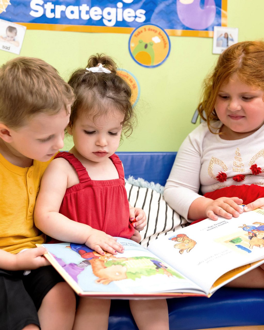 Three children reading a book together