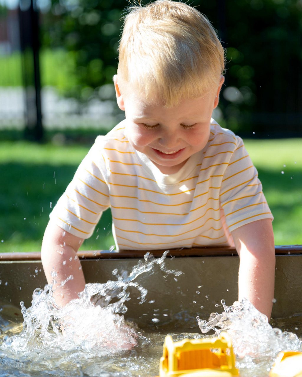 A child splashing in a water table 