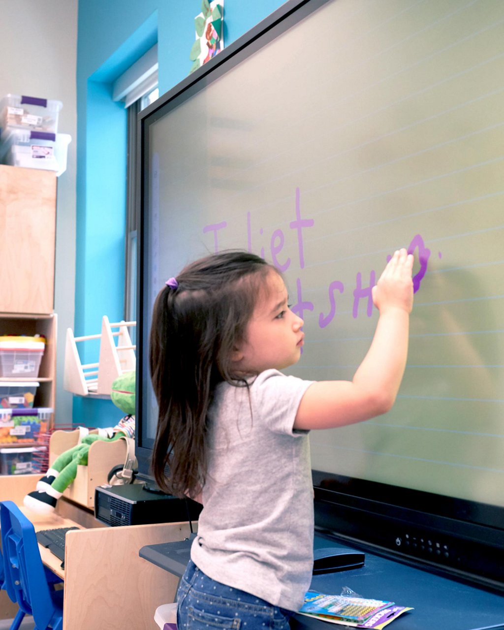 A child writing on a smart board 