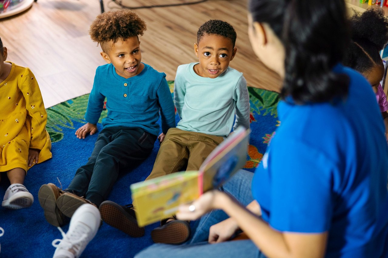Goddard School teacher reading to children in a classroom