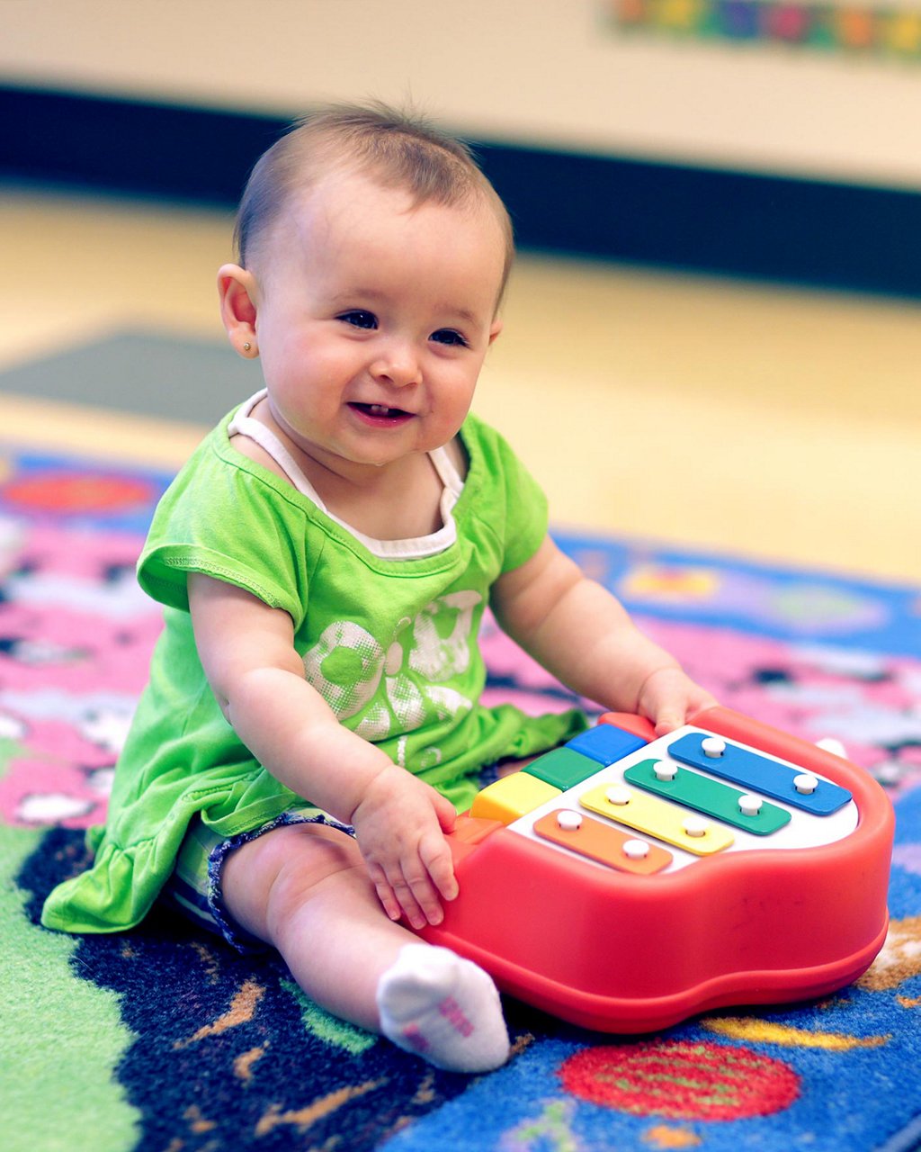 Infant playing with a toy piano