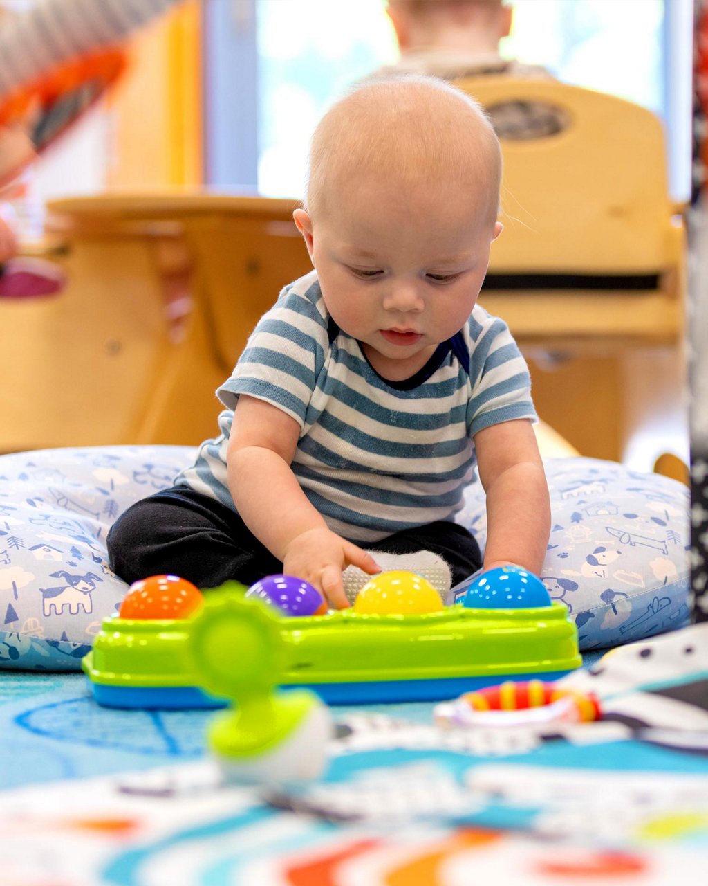 Infant playing with a colorful toy