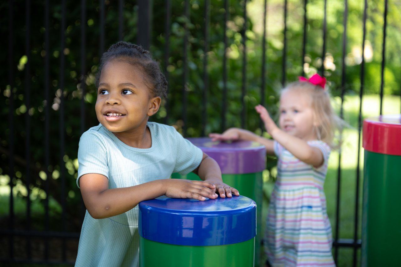 Two young girls playing in an outdoor classroom