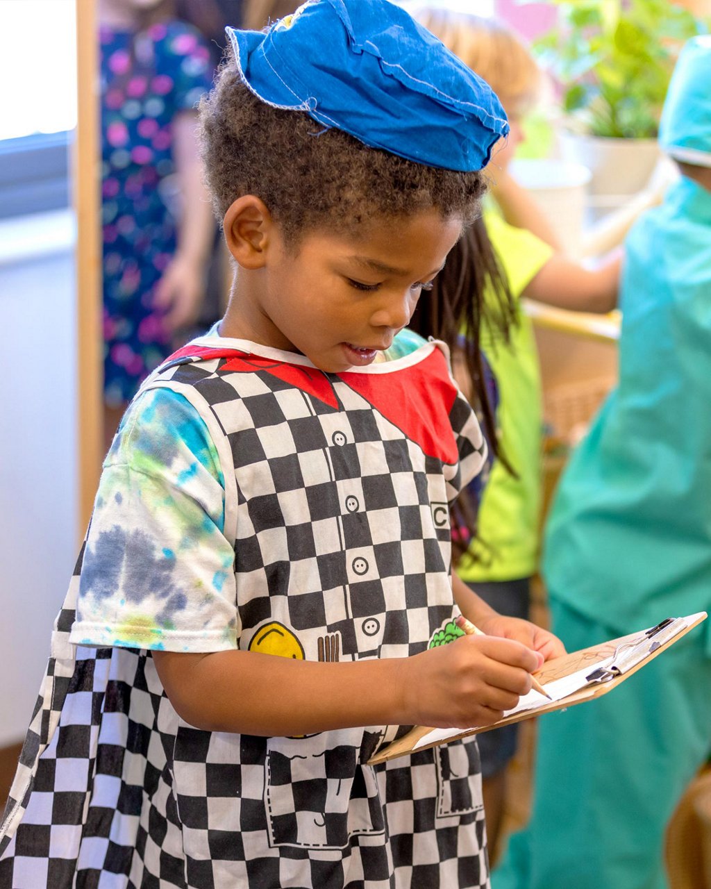 A child dressed in a costume writing on a clipboard