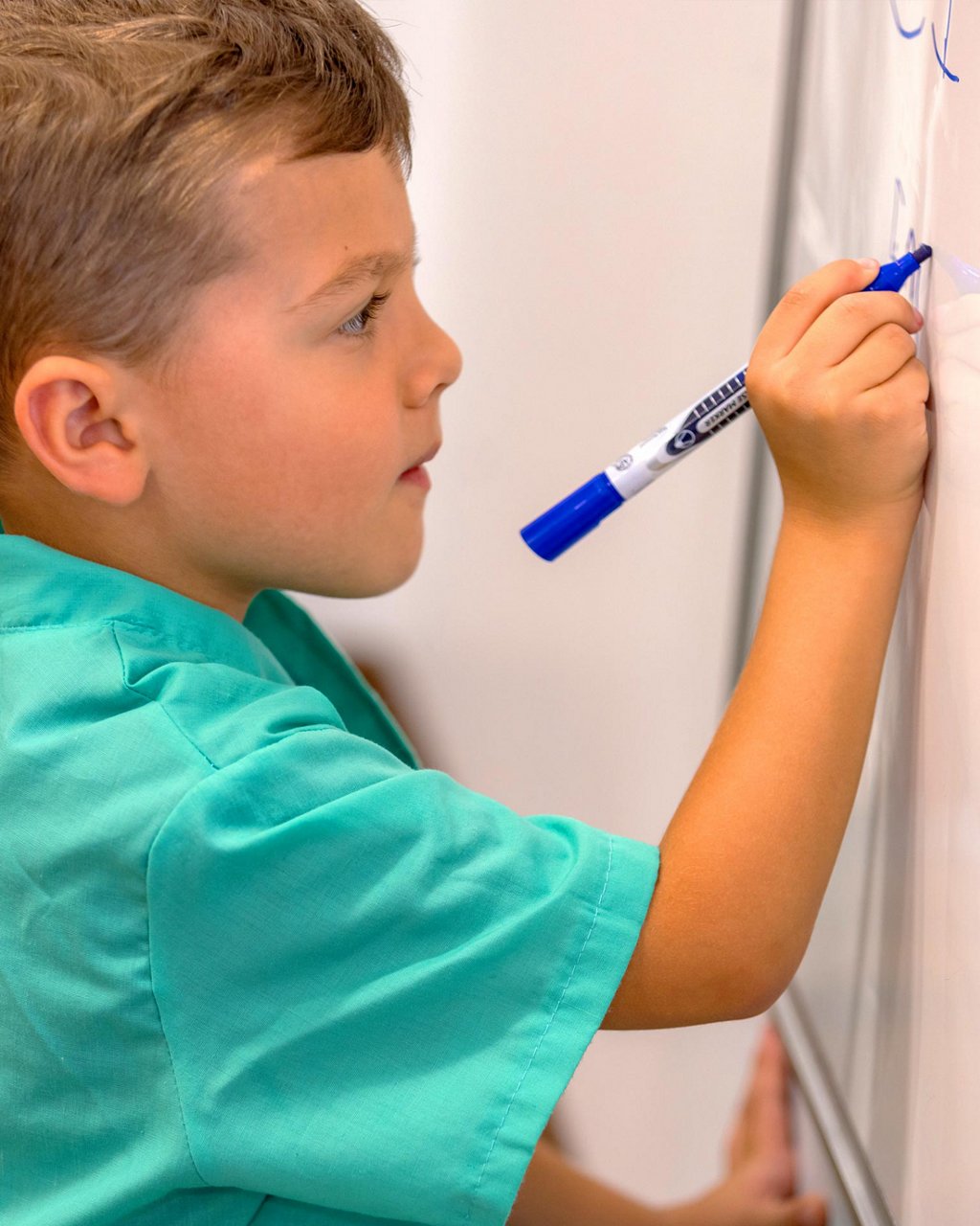 A child writing on a whiteboard 