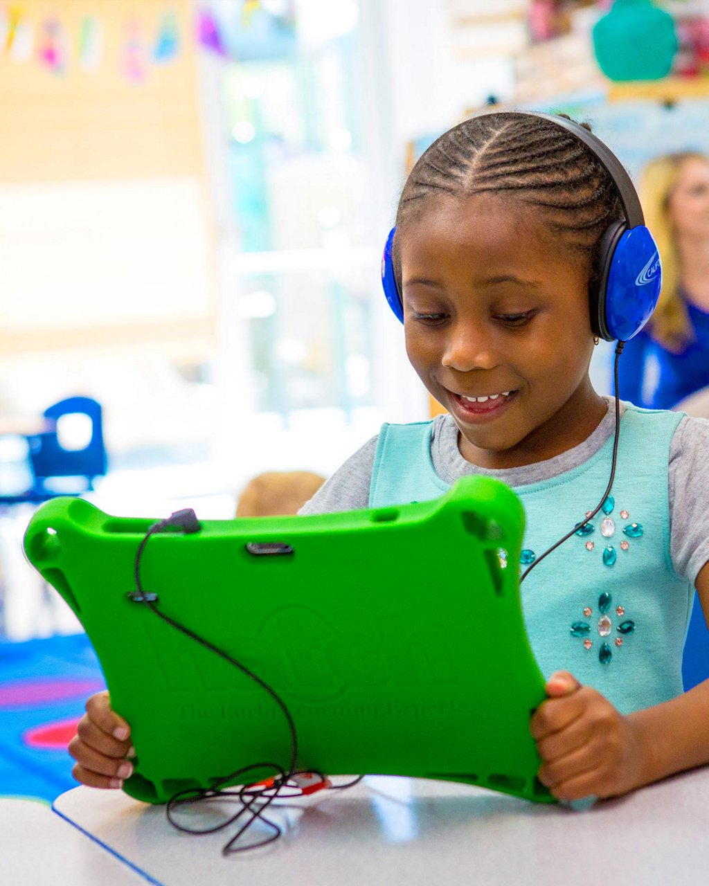 A child wearing headphones playing on a tablet 