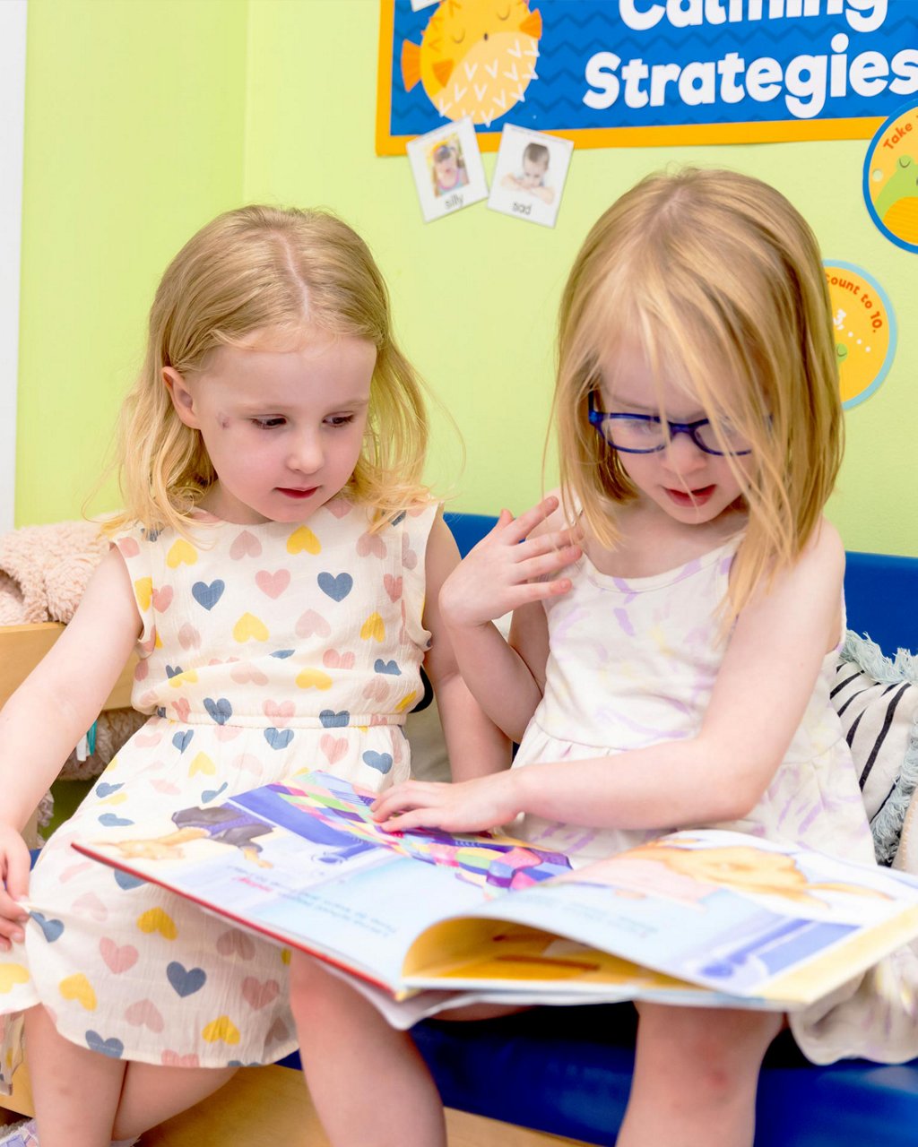 Two children reading a book together 