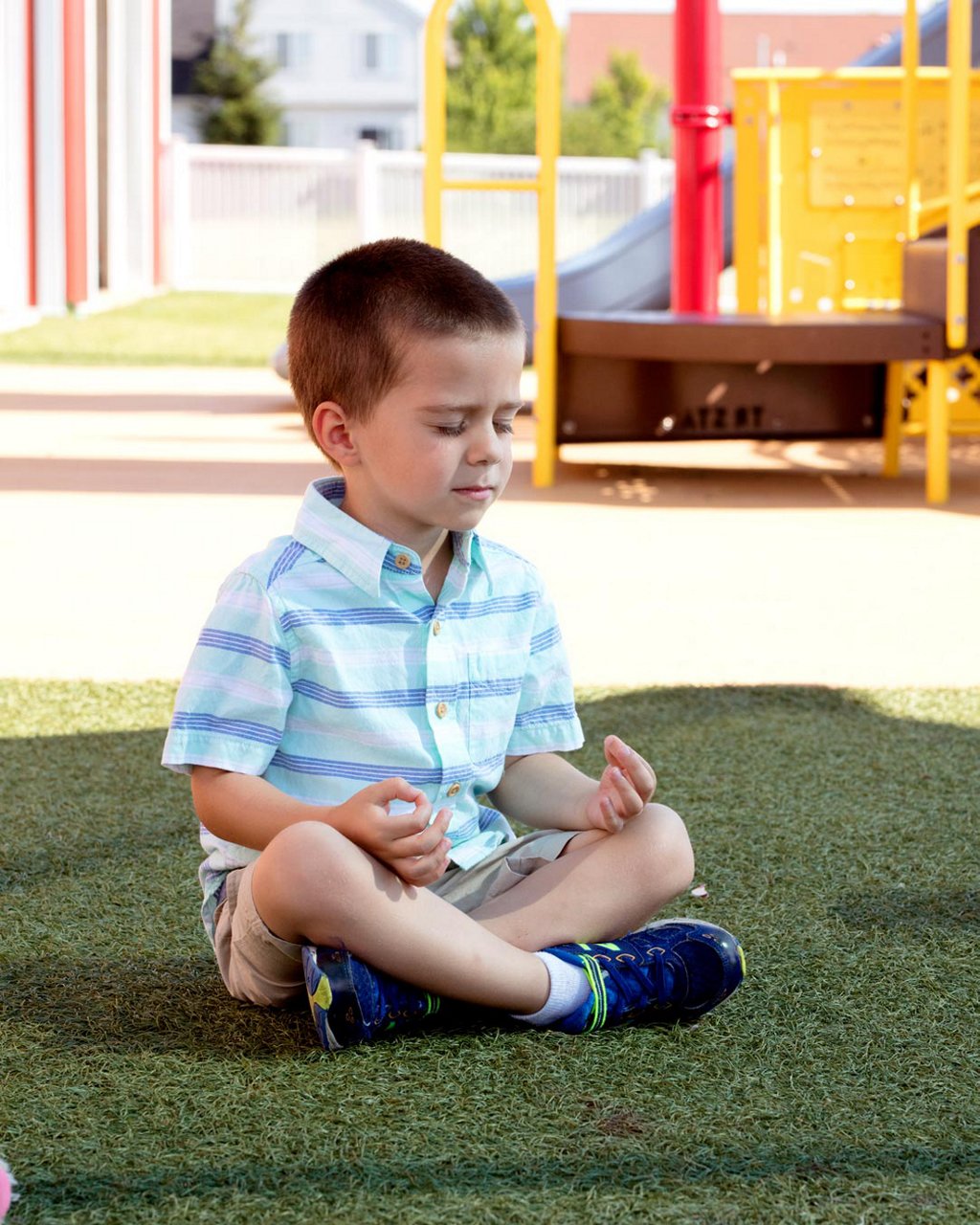 A child meditating on a playground 