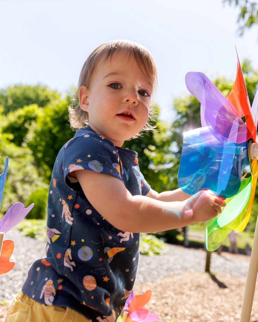 A child playing with colorful items in an outdoor classroom