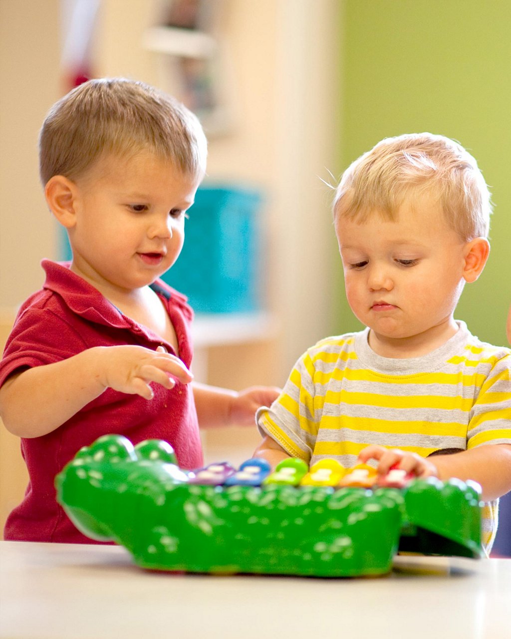 Two children playing with a keyboard toy 