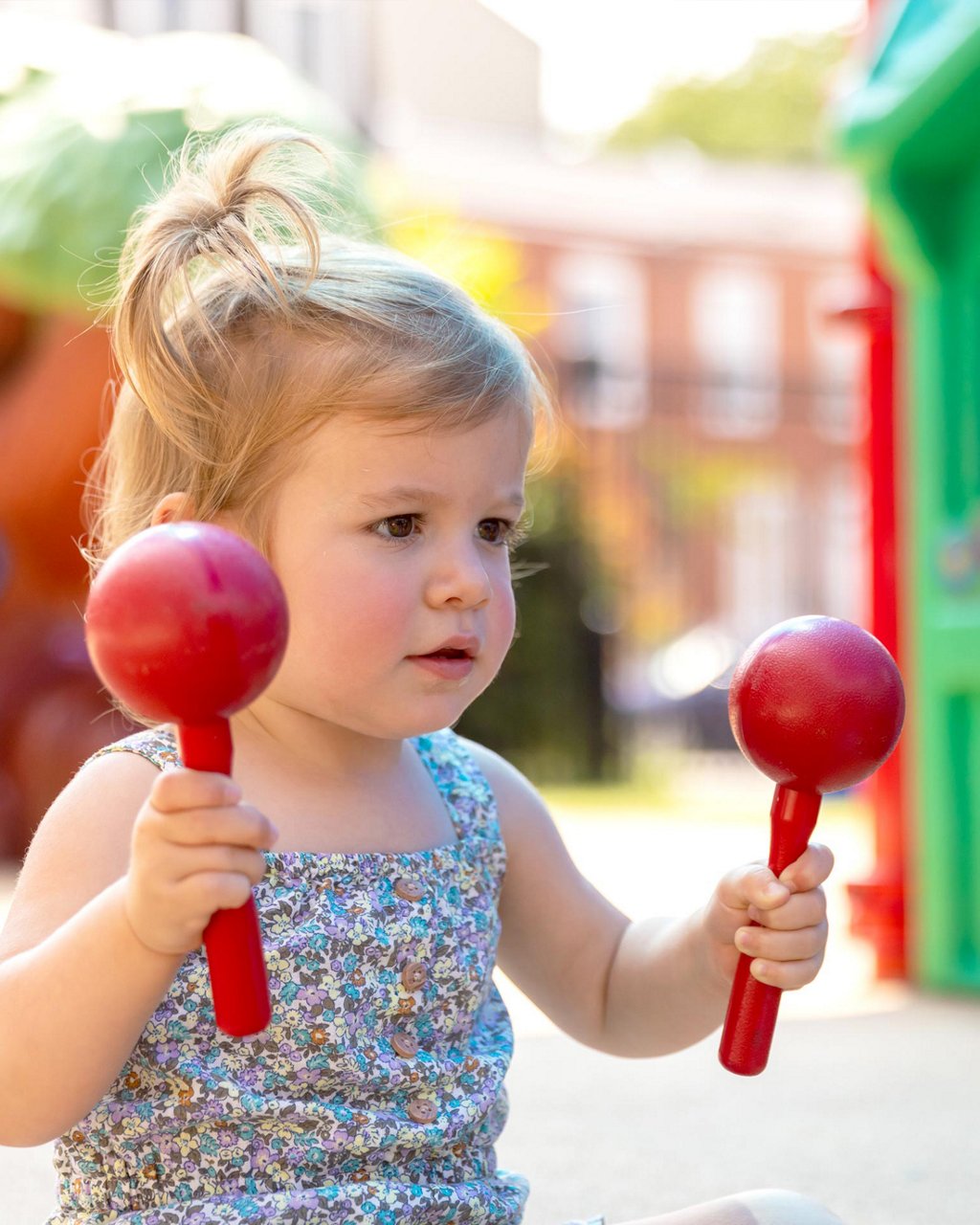 A child playing maracas on a playground 